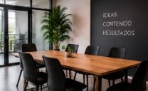 Sala de reuniones con mesa de madera y muro que dice ideas, contenido, resultados