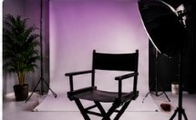 Estudio de fotografía con silla de director, fondo lila y softbox
